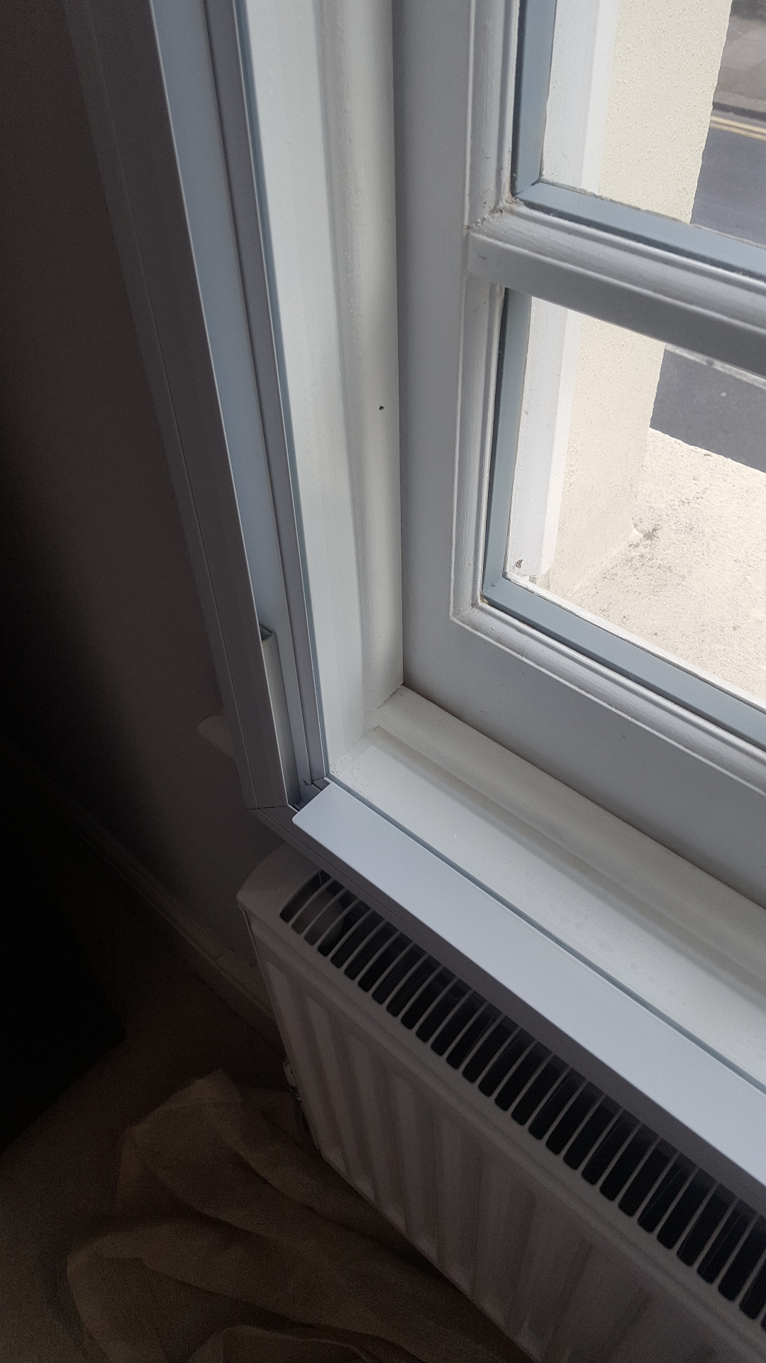 Close-up of secondary glazing installation with radiator showing thermal efficiency features